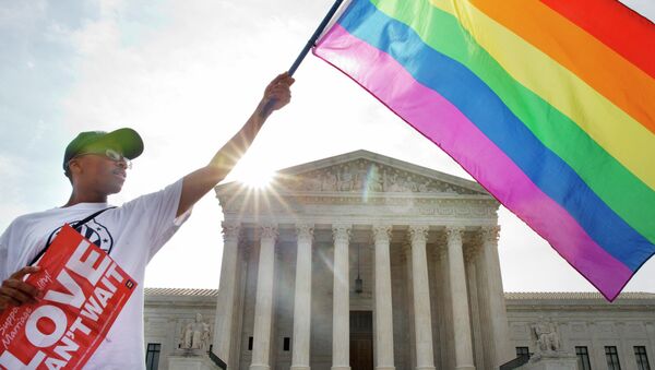 Активист держит флаг ЛГБТ у здания Верховного суда США в Вашингтоне. Архив