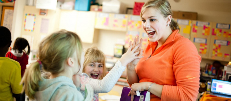 учительница улыбается ученицам