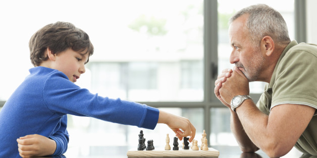 мальчик играет с мужчиной в шахматы