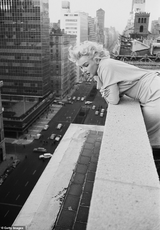 Marilyn looks over the parapet of the Ambassador Hotel in New York while enjoying a cigarette 