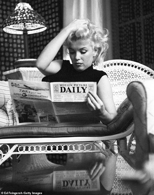 Stunning rare photographs of Marilyn Monroe relaxing at her hotel room in New York, reading a newspaper and enjoying a glass of wine have gone on display at a London gallery