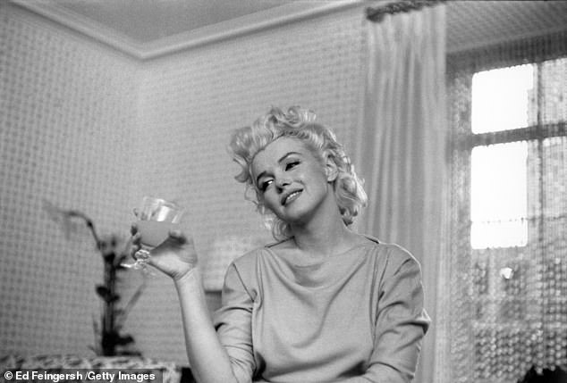 In this one Marilyn enjoys a glass of wine at her home in New York, March 1955