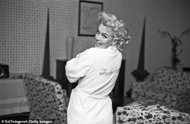Marilyn  wears an embroidered robe that reads 