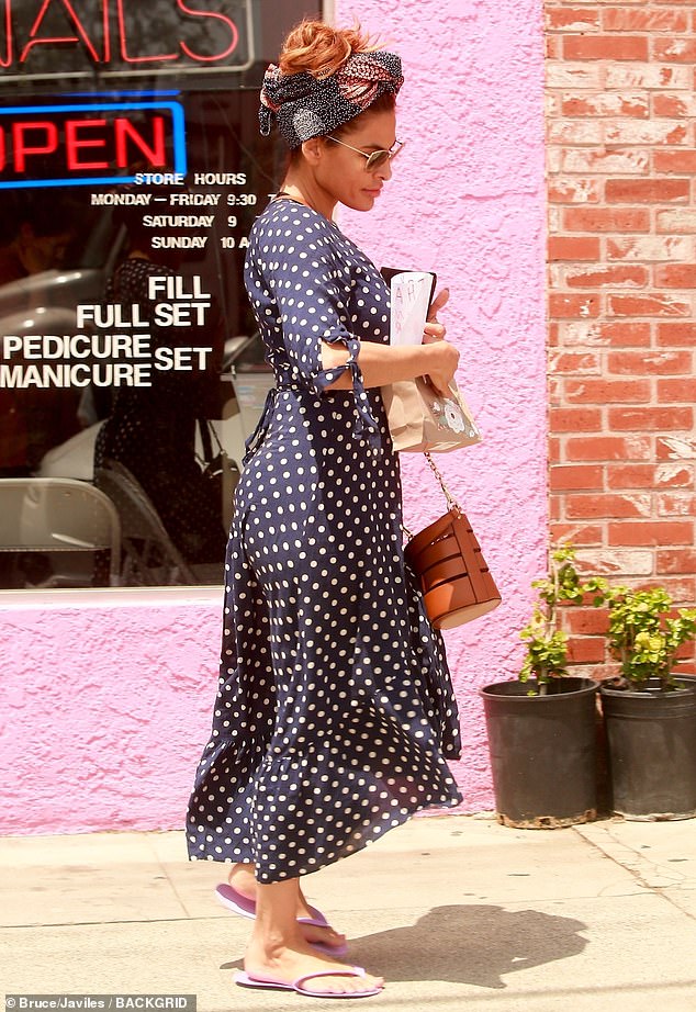 Hands full: Mendes (born Méndez) donned a navy polka dot dress, patterned head scarf, and disposable flip-flops from her pedicure