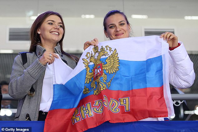Alina Kabaeva and pole vaulter Yelena Isinbayeva cheer on the men
