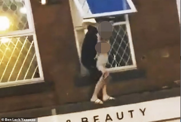 A man dangled a child from a ledge above a ten foot drop as a horrified crowd gathered below in Station Road, Wakefield, west Yorkshire, yesterday