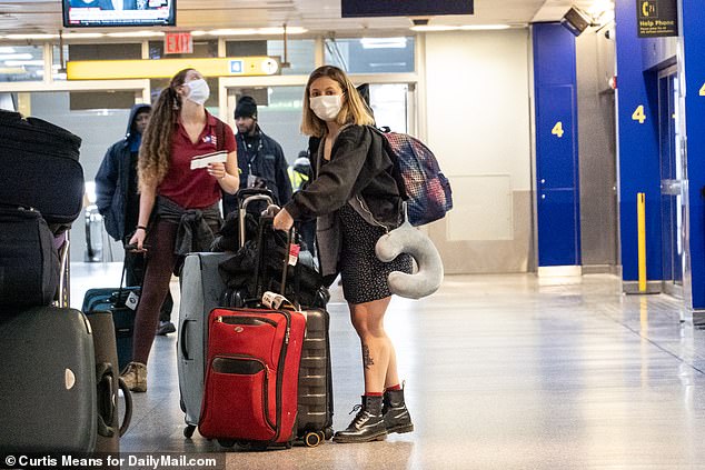 The CDC dropped its recommendation that travelers self-quarantine for 14 days. Travelers are seen wearing masks at New York City