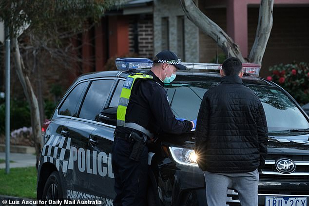 A 24-year-old Hallam man was slapped with his 24th coronavirus penalty notice on Thursday evening. A police is seen talking to a man following a protest in Dandenong earlier this week