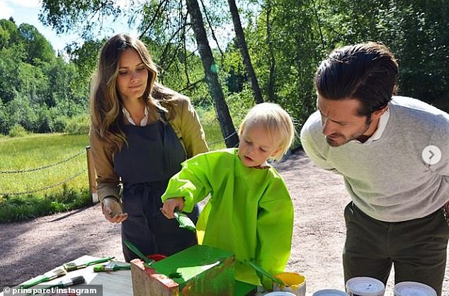 The young royal, pictured painting a tree house with his parents, toured Saterdalen nature reserve on Thursday