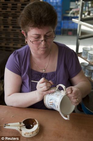 Intricate: Worker Linda Hancox gilds the first of a limited edition of 1,000 Loving Cups, to be part of the official Royal Wedding commemorative china