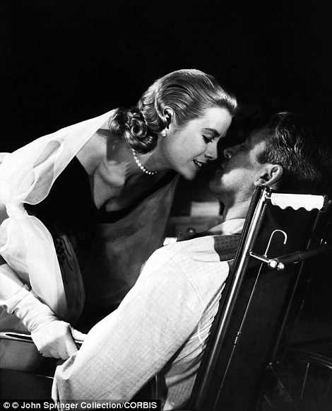 Lisa Carol Fremont (Grace Kelly) leans in to kiss L.B. Jeffries (James Stewart) in a scene from the classic 1954 Alfred Hitchcock film, Rear Window