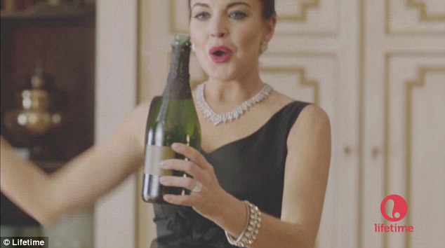 Throwing herself into the role: Lindsay Lohan clutches a bottle of champagne as she takes on the role of Elizabeth Taylor in the new Liz & Dick promo