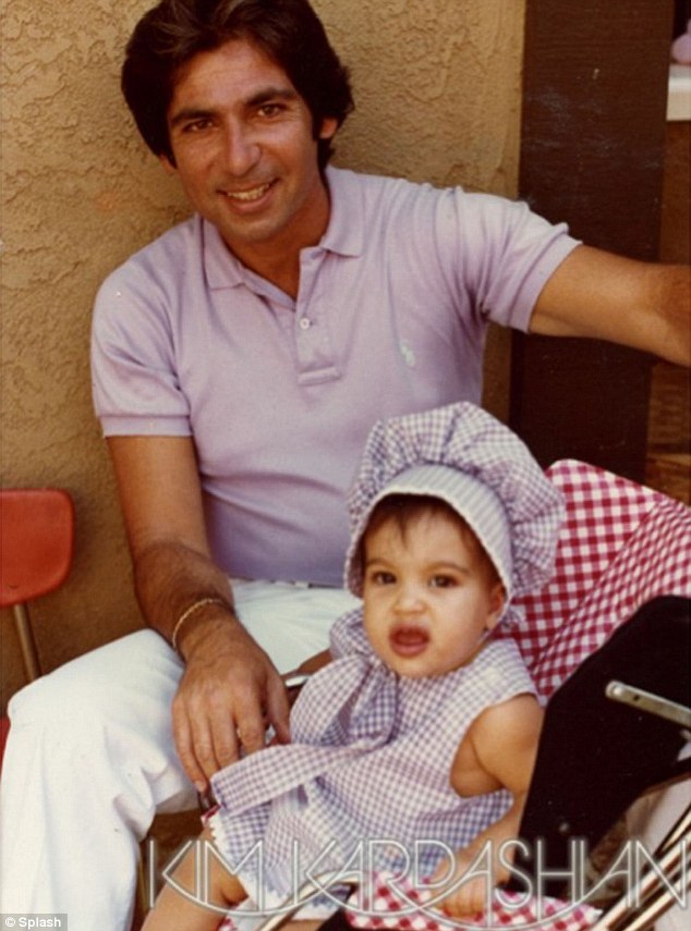 Doting dad: Kim posted this tribute picture on her website of her as a baby with her lawyer father Robert who passed away in 2003
