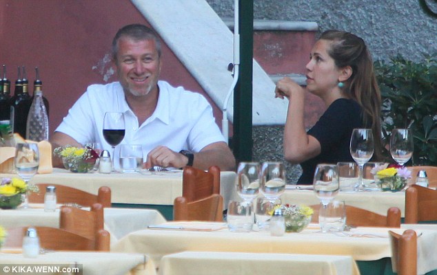 Roman Abramovich smiles broadly as he relaxes in an empty Portofino restaurant with Dasha Zhukova