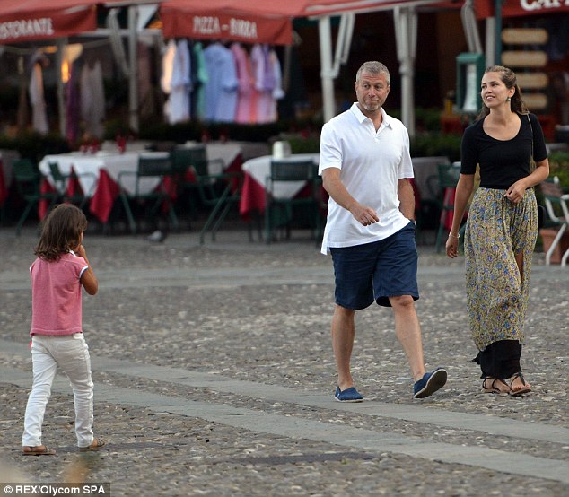 The couple greet a young girl as they walk through the picturesque Italian streets