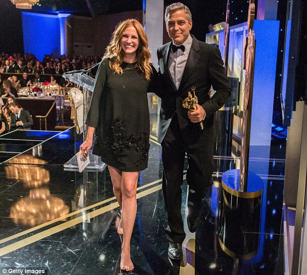 Clothing trickery: The actress wore a loose-fitting dress suggesting she might have been hiding a baby bump as she walked off stage with George Clooney at the 2013 
