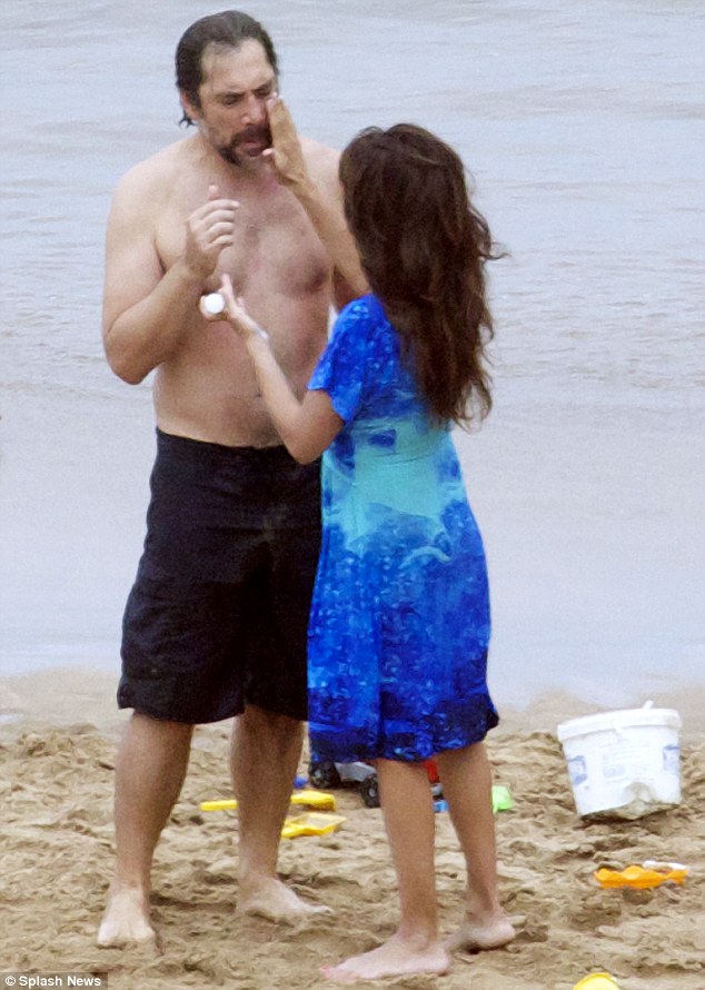 Come here, you! Penelope Cruz rubs suncream on husband Javier Bardem as they enjoy a family holiday in Tenerife