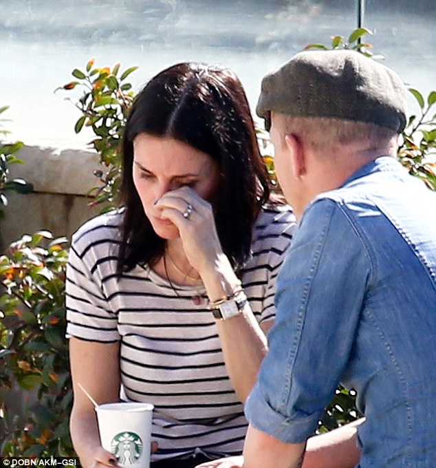 Drying her eyes: The Cougar Town star - who was dressed casually in a striped T-shirt and jeans - wiped away a tear as her pal looked on