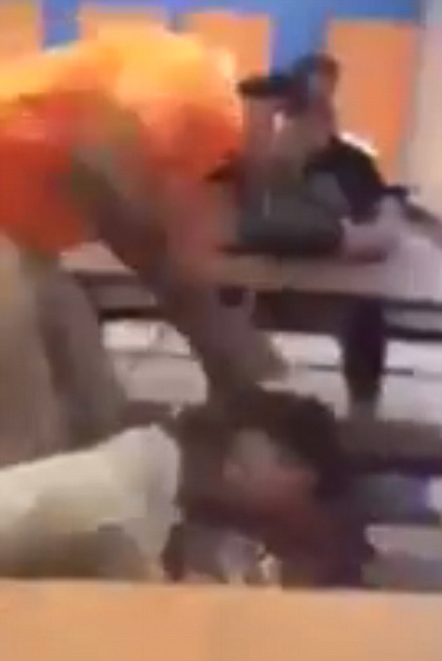 Brutal: The fight that broke out at Frederick Douglass High School in Baltimore on Wednesday - which was captured on video - has left one student in the hospital and another charged with attempted murder