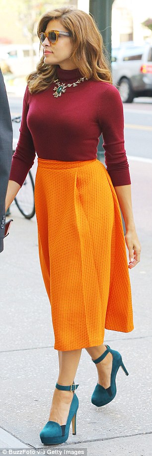 Strutting in the city:  Wearing a maroon turtleneck, bright orange calf length skirt and teal heels, the new mom look radiant on the morning show