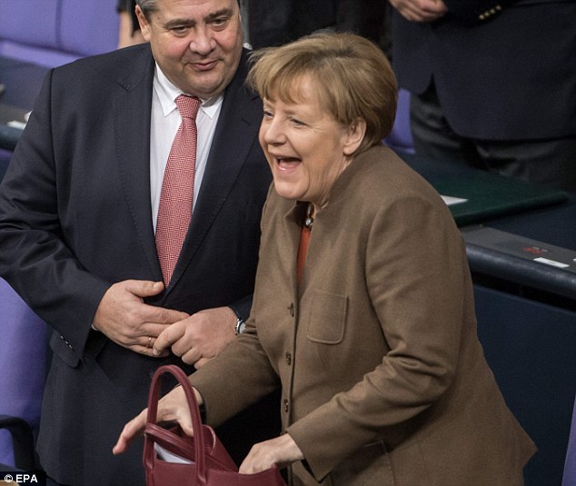 Happy days? Mrs Merkel laughs next to Minister of Economic Affairs Minister Sigmar Gabriel, at the Bundestag in Berlin, Germany