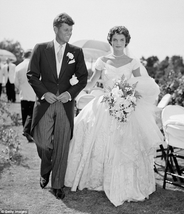 American royalty: John F. Kennedy is pictured walking alongside his bride Jacqueline Kennedy née Bouvier at their 1953 outdoor wedding reception in Newport, Rhode Island 