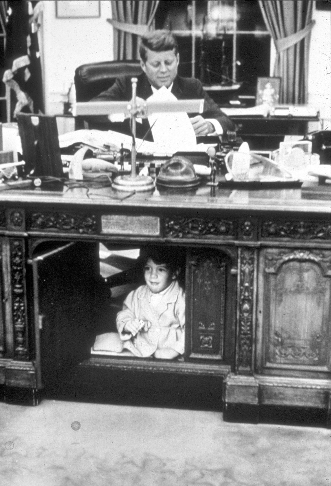 Джон Ф. Кеннеди-младший играет в Овальном кабинете, пока его отец работает, 