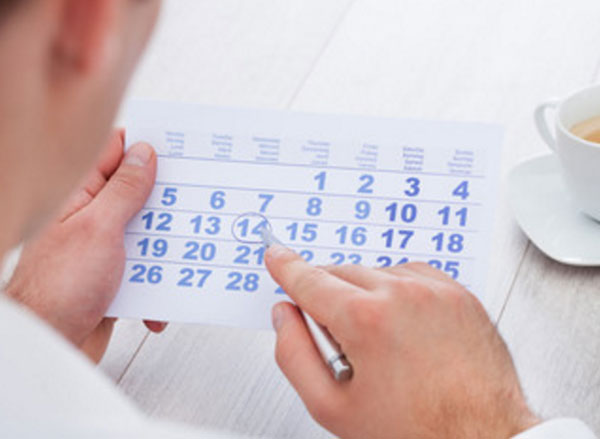 Мужчина обводит ручкой число в календаре