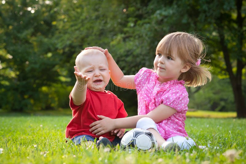 Brother and sister. Sitting on the grass royalty free stock photography