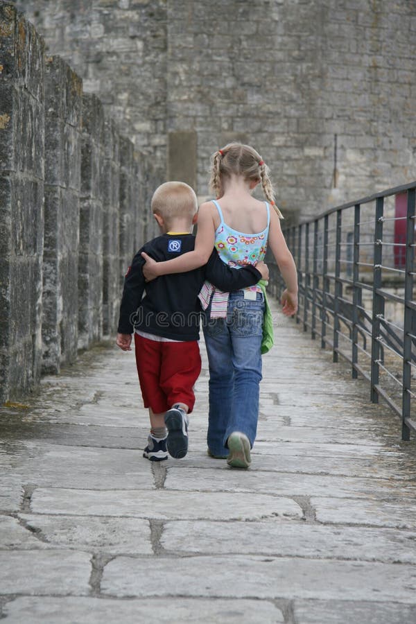 Brother & Sister. Brother and Sister walking together arm in arm as friends royalty free stock photo