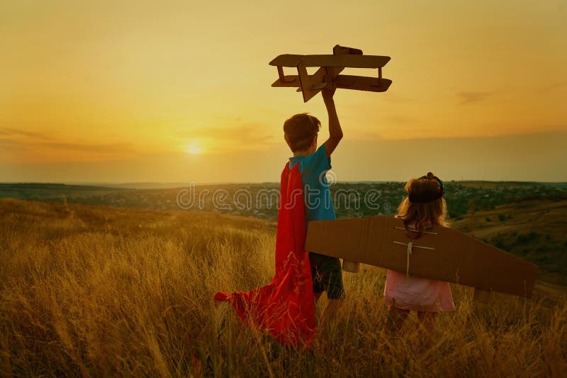 Brother and sister in suits of superhero pilots at sunset. Brother and sister in suits of superhero pilots in nature at sunset royalty free stock photo