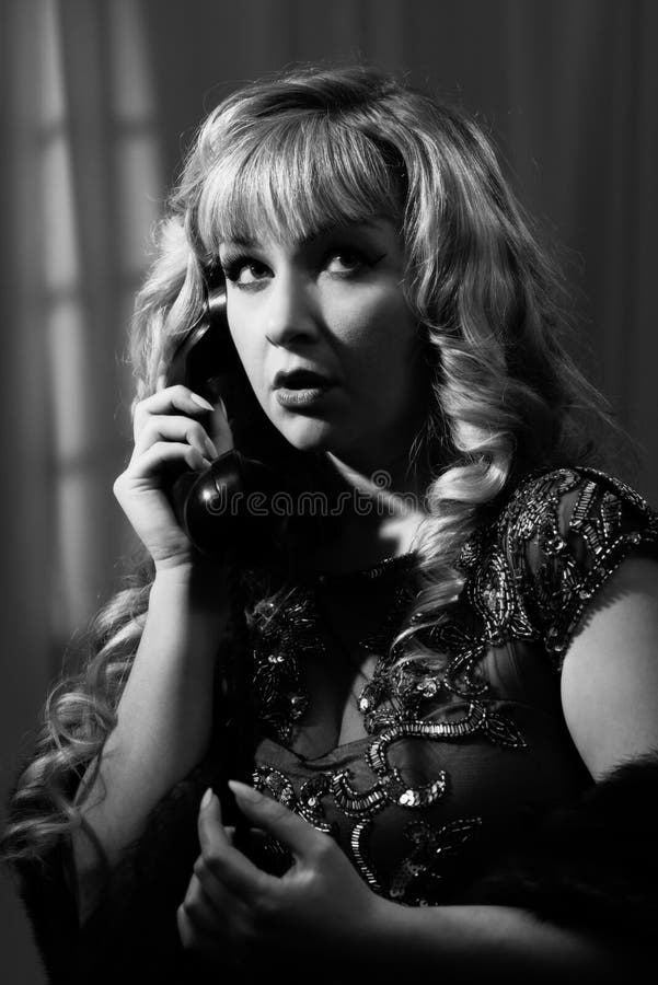 Film Noir Woman. Film Noir style black and white image of woman on a vintage telephone royalty free stock images