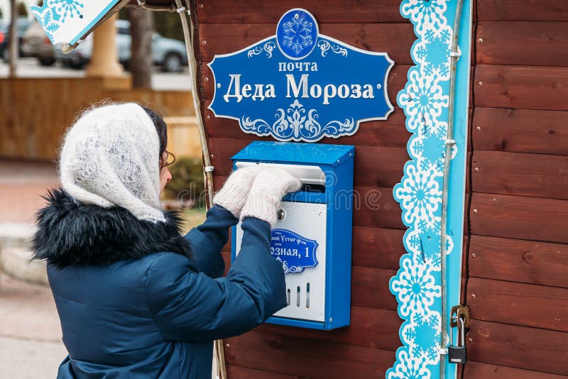 23, 2018: The girl in white mittens sends a letter to Ded Moroz in the mailbox. Yessentuki, Stavropol Territory / Russia - December 23, 2018: The girl in white stock photography