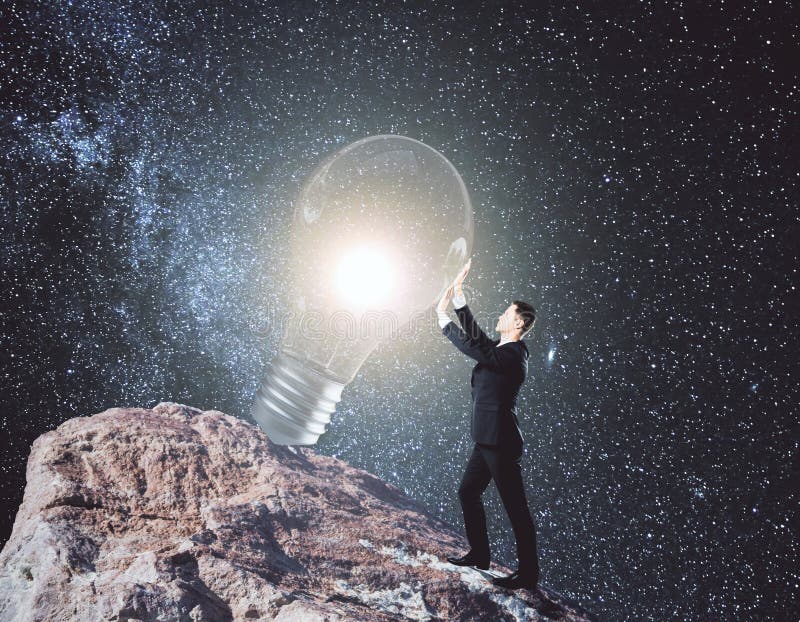 Imagination concept. Side view of young businessman on rock hill holding glowing light bulb. Space background. Imagination concept. 3D Rendering royalty free stock photos