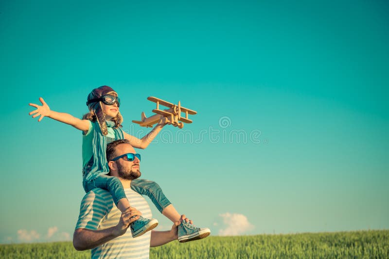 Imagination and freedom concept. Happy child playing with father outdoors. Family having fun in summer field. Travel and vacation concept. Imagination and stock photography