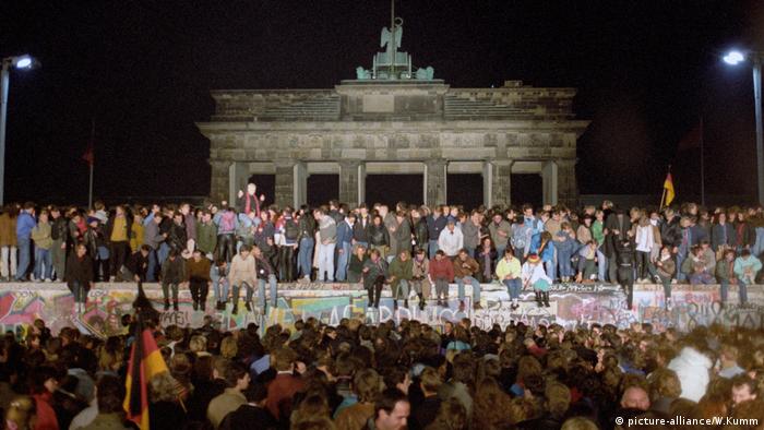 People stand on the Berlin Wall when it opened up on November 9, 1989 (picture-alliance/W.Kumm)