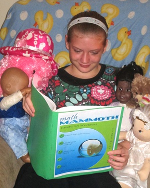 child studying Math Mammoth grade 3-A student book, with dolls